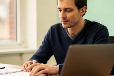 Kmo-ondernemer bekijkt een betaalrapport op een laptop in een kantoor